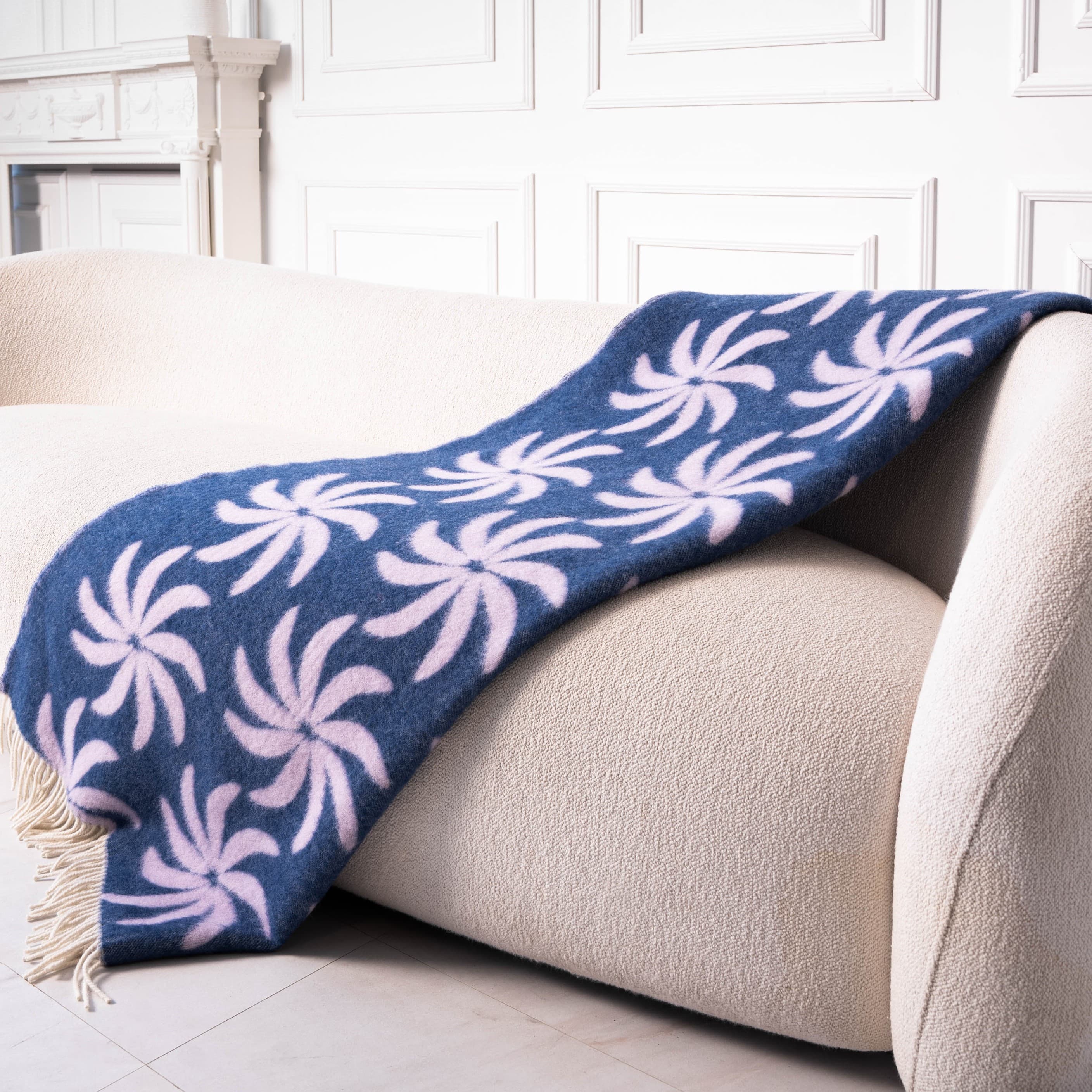 Blue and lilac floral wool blanket neatly placed on sofa – WOLIQ Coastal Bloom