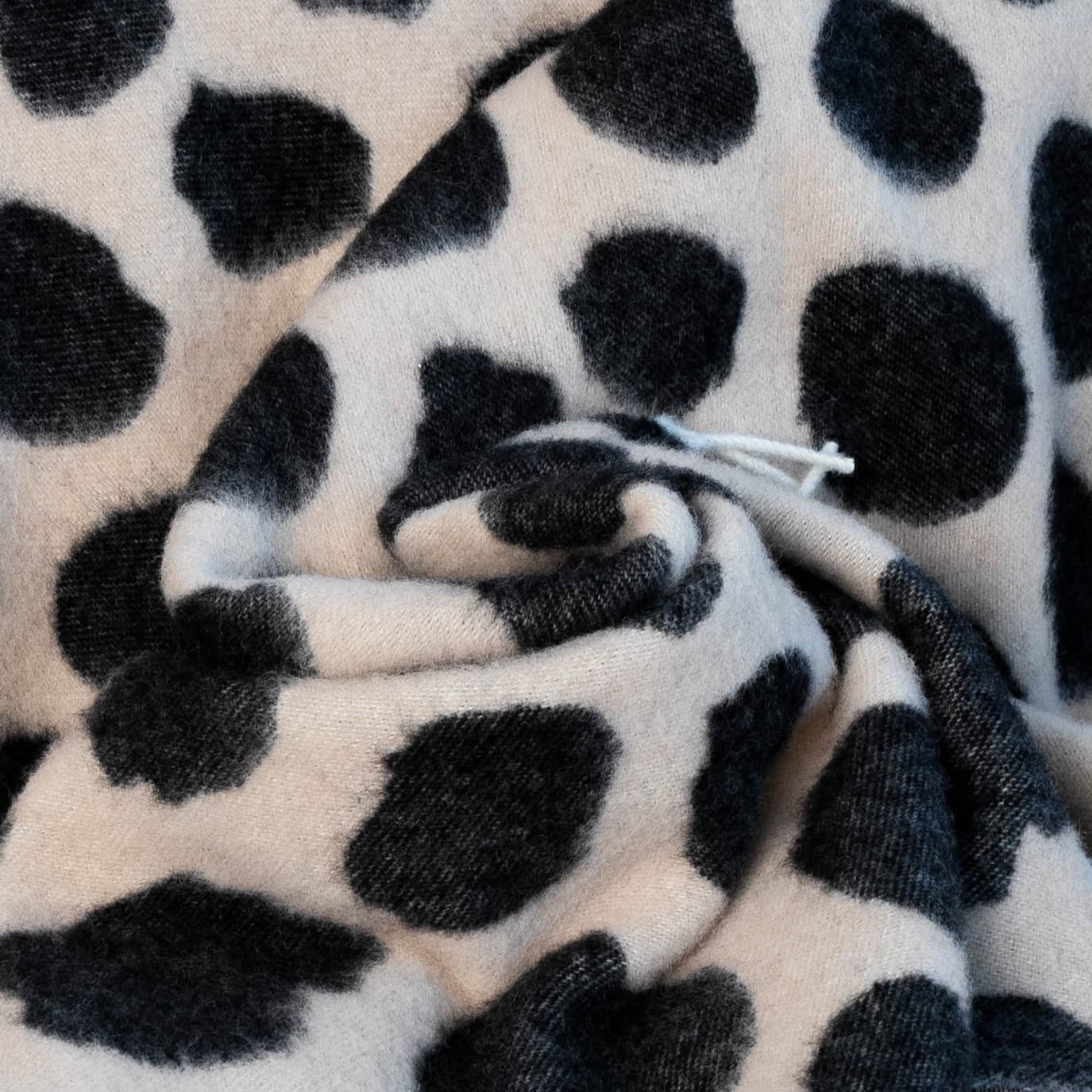 Texture detail of black and brown cow print wool blanket – WOLIQ Earthbound