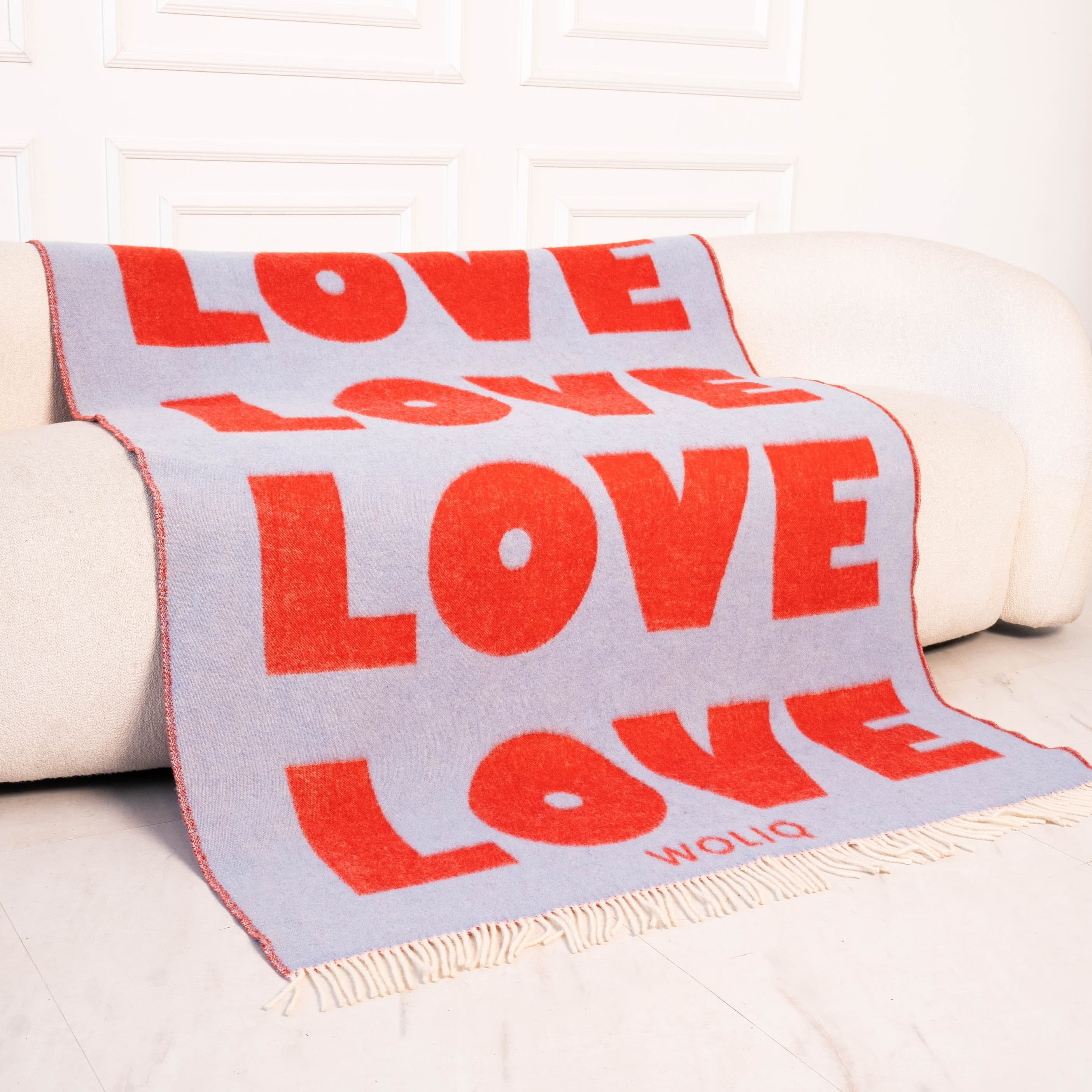 Red and light blue text pattern wool blanket on sofa – WOLIQ Endless Love