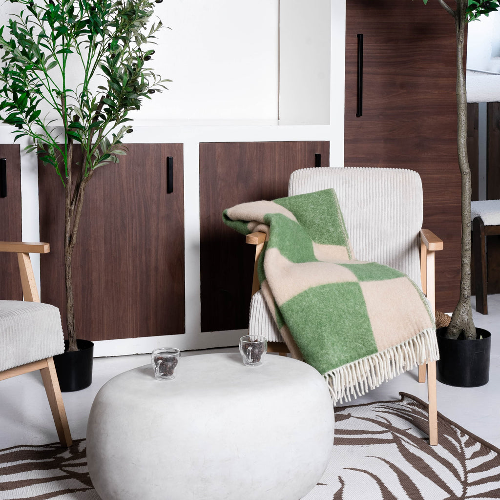 Green and beige cube illusion wool blanket draped on chair – WOLIQ Gentle Shift