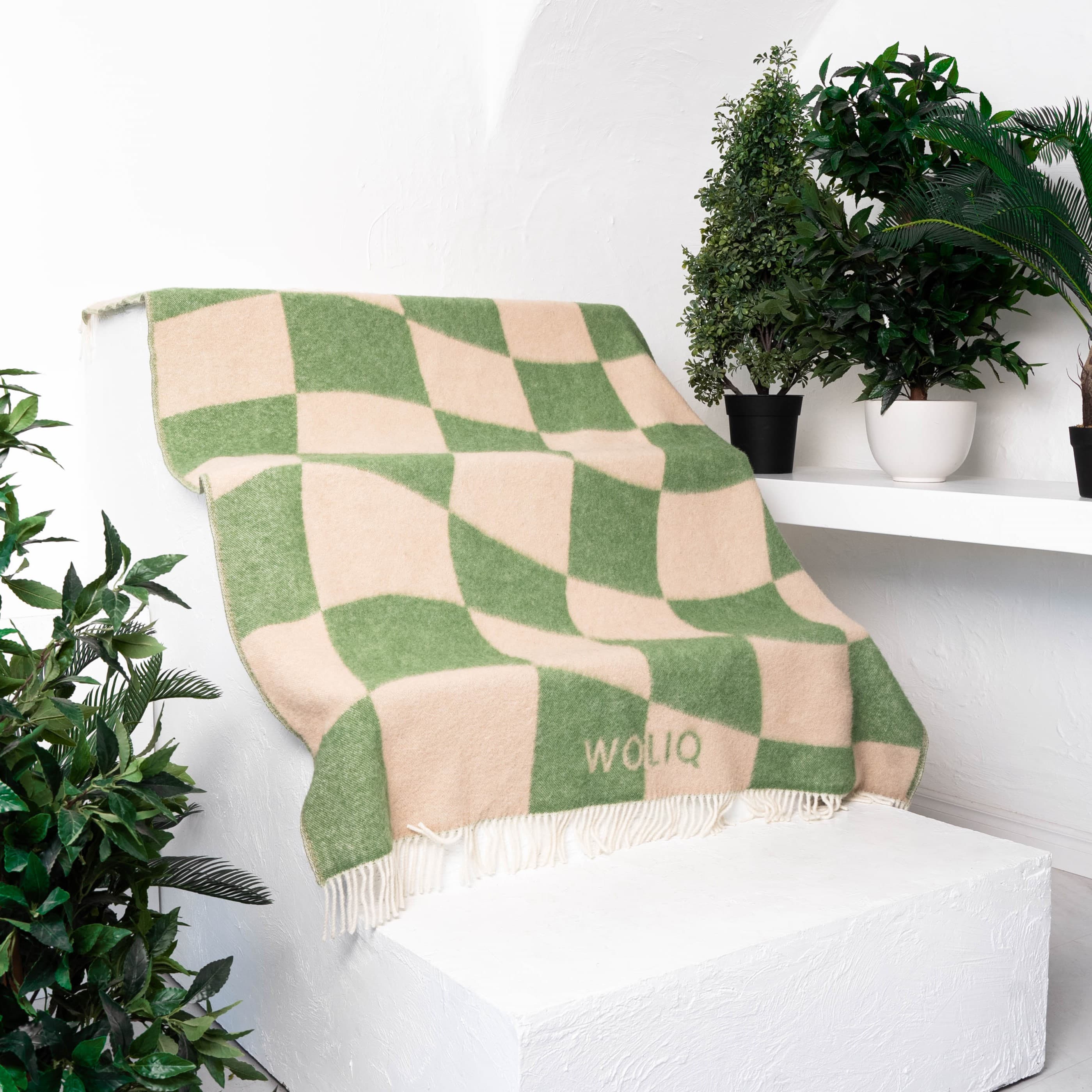 Green and beige cube illusion wool blanket placed on stairs – WOLIQ Gentle Shift