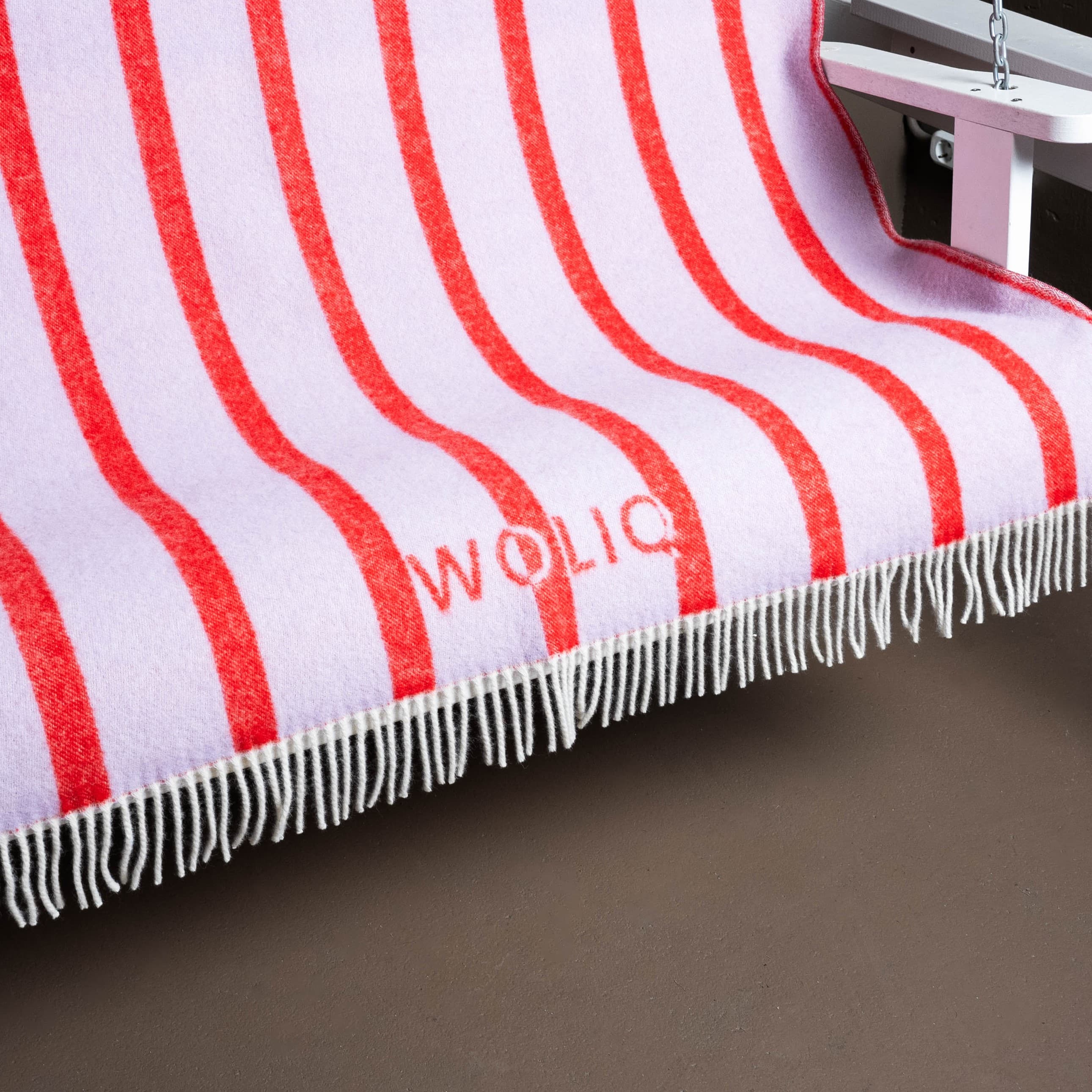 Close-up of pink and red striped wool blanket on swing – WOLIQ Hug Me