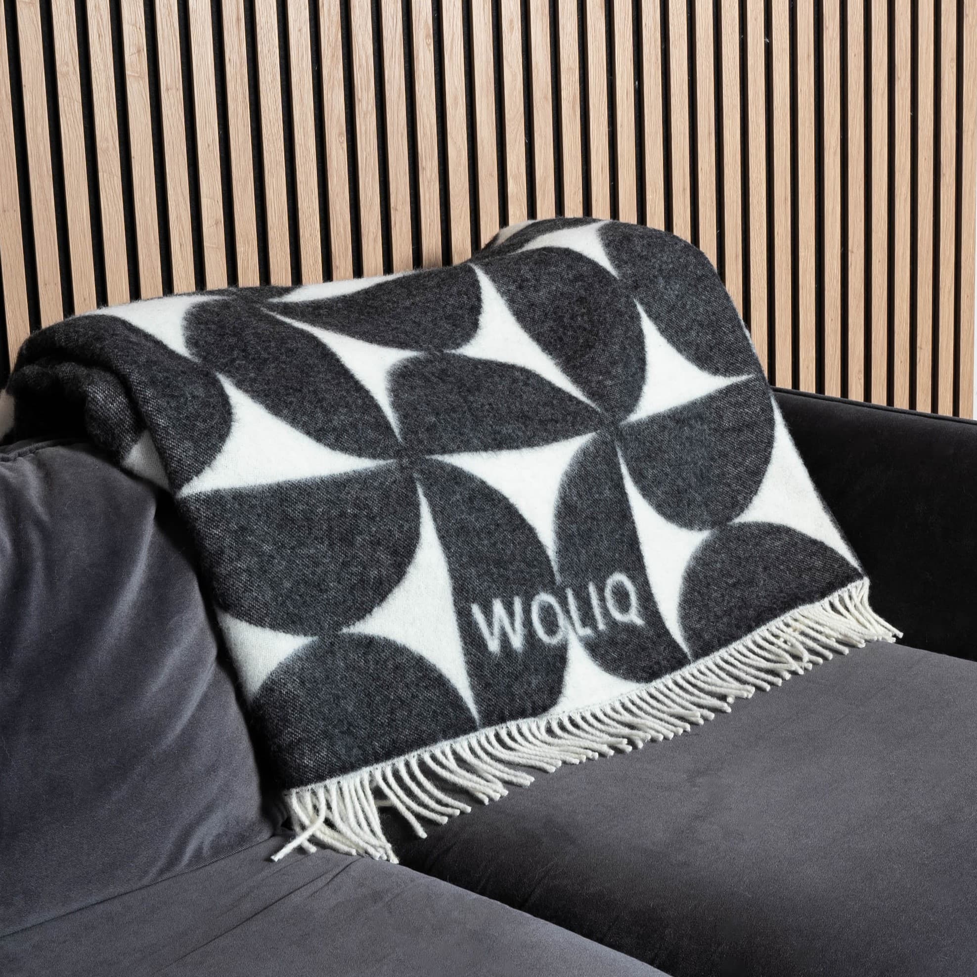 Black and white Bauhaus wool blanket neatly placed on sofa – WOLIQ Mono Bauhaus