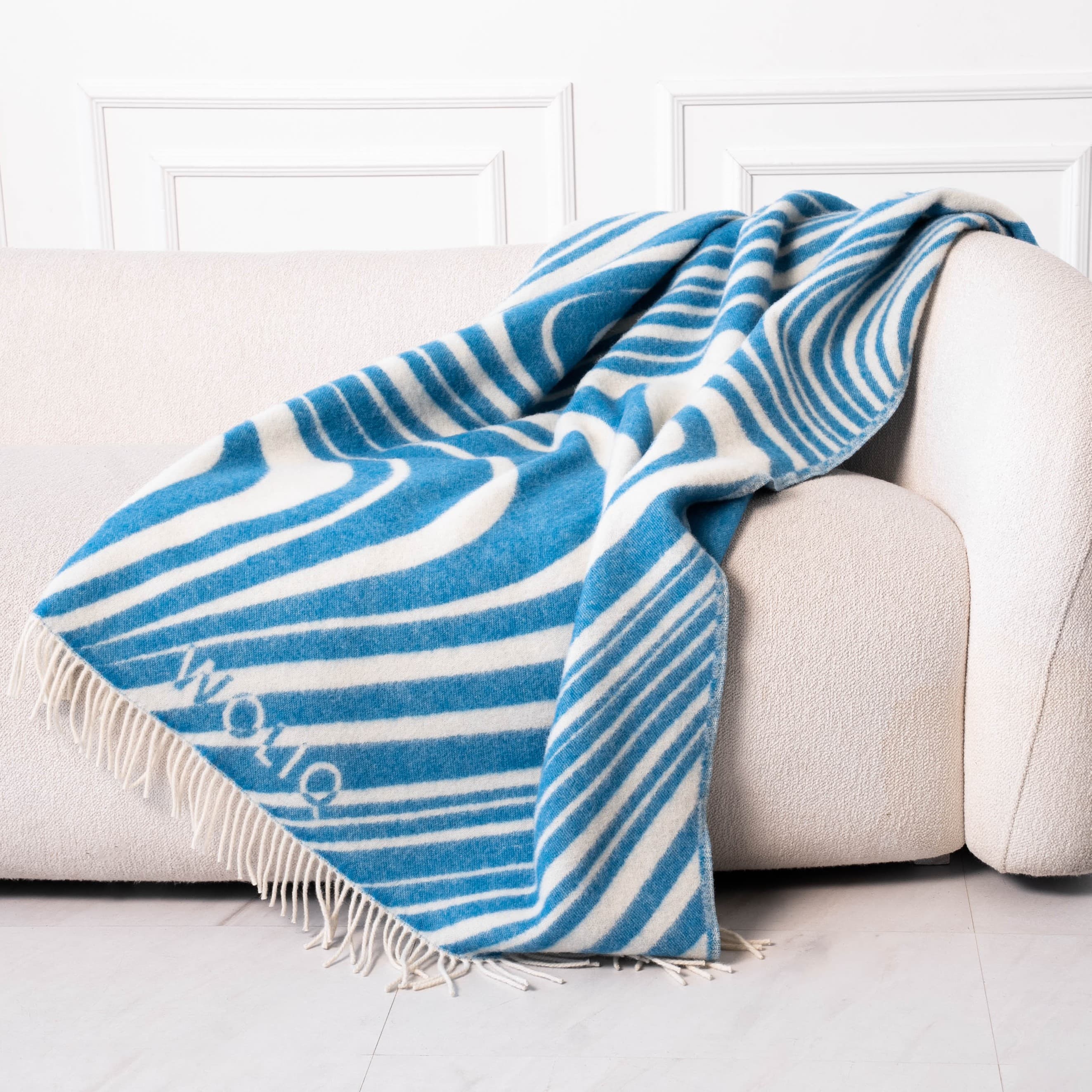 Blue and white wavy pattern wool blanket on sofa – WOLIQ Ocean Rhythm