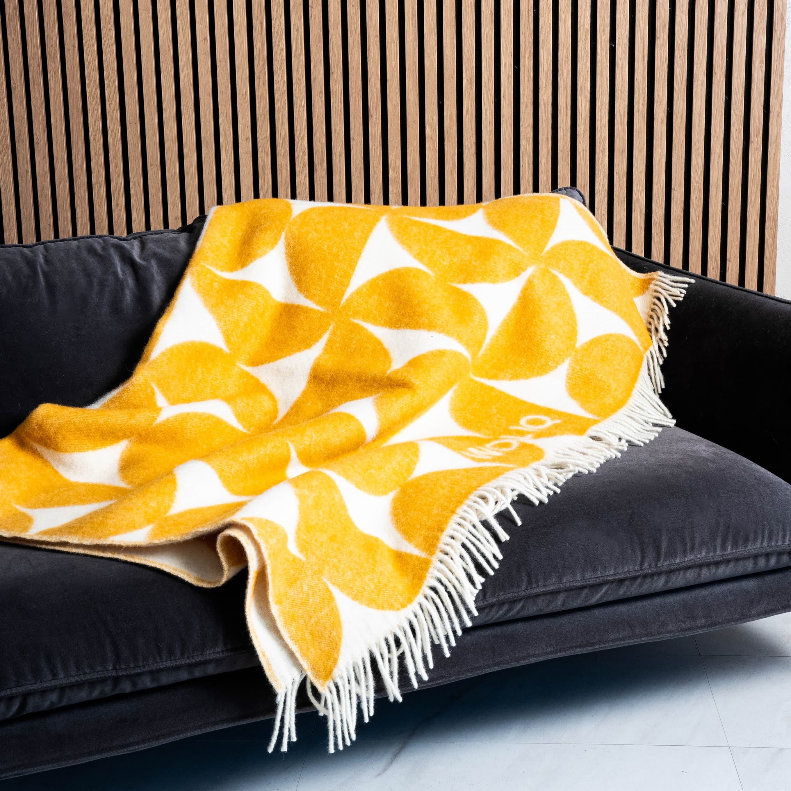 Yellow and white Bauhaus wool blanket draped on sofa – WOLIQ Solar Bauhaus