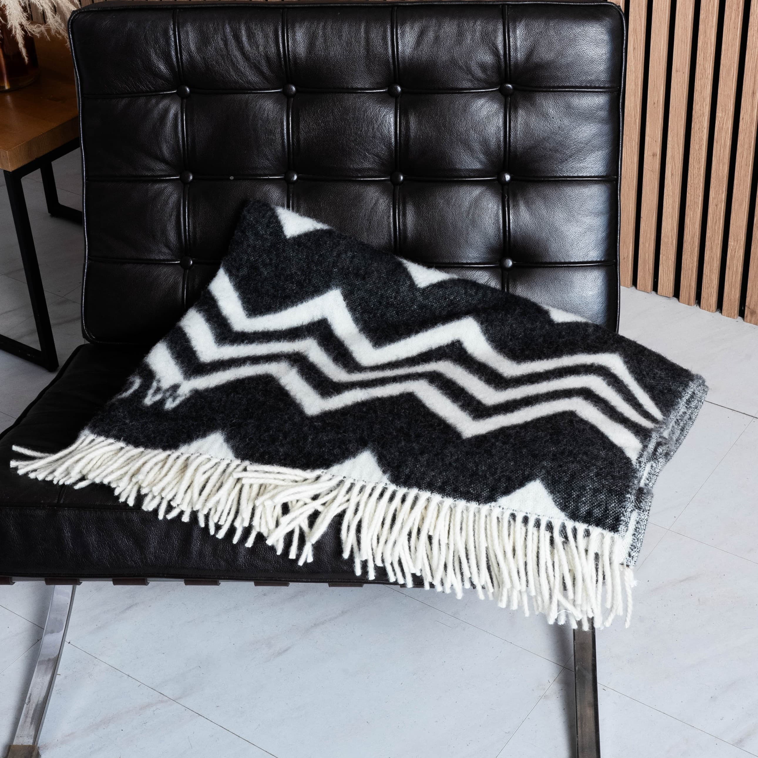 Black and white zigzag wool blanket draped over chair seat – WOLIQ Static Motion